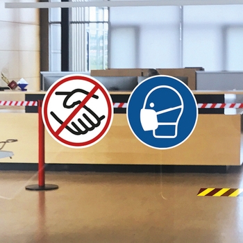 Tür mit Hinweisschildern: Händeschütteln verboten und Atemschutzmasken tragen.
