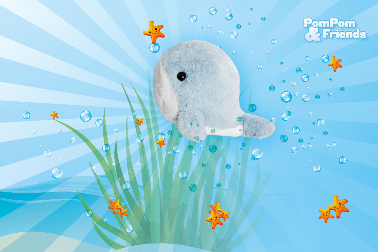 Ein blauer Plüschwal schwimmt unter Wasser, umgeben von Luftblasen und orangefarbenen Seesternen, mit grünem Seegras im Hintergrund.