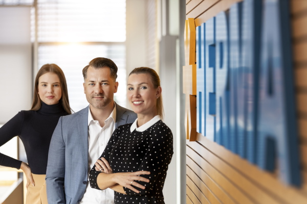 Mitarbeiter vor dem Firmenlogo