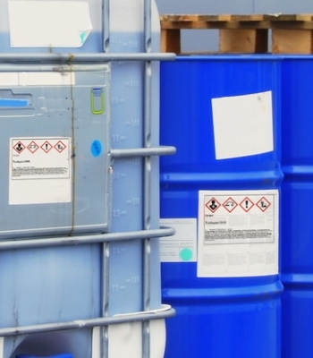 Gefahrstoff- und Gefahrgut-Etiketten: Gefahrstoffetiketten auf Chemiebehältern im Außenbereich