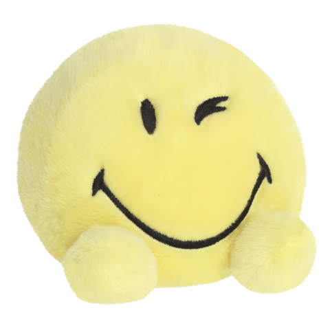 Gelbes, lächelndes Kissen in Form eines Smiley mit einem zwinkernden Auge und zwei kleinen, runden Füßen.
