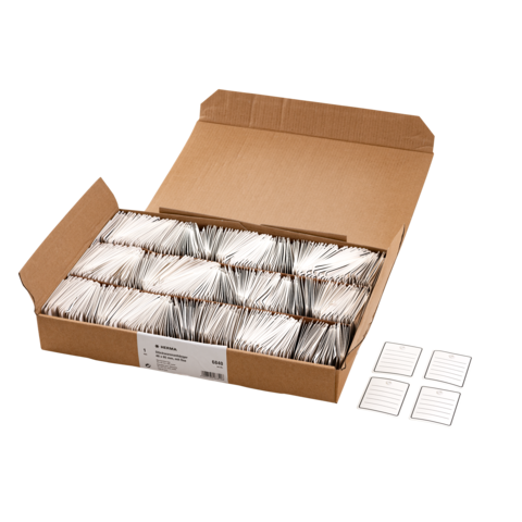 Ein Karton mit zahlreichen weißen Karteikarten, daneben vier leere Karteikarten mit Linien.