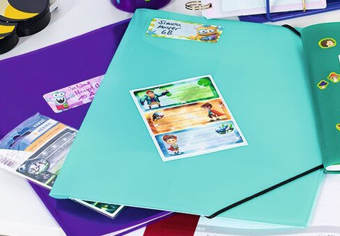 Sammelmappen und Schuletiketten auf dem Schreibtisch