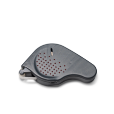 Ein graues, ergonomisch geformtes Gerät mit roten Punkten, vermutlich ein elektronischer Signalgeber oder Alarm.