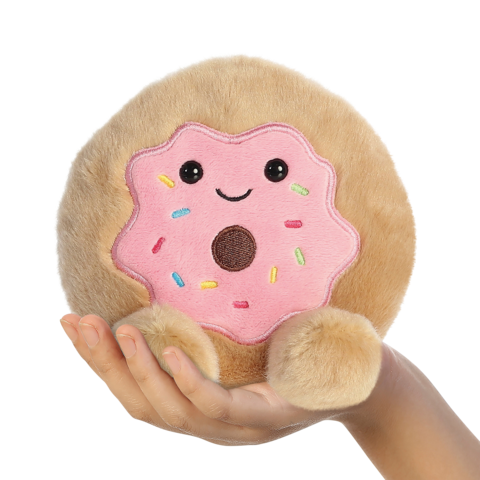 Ein handlicher, runder Plüschkeks mit rosa Zuckerguss und bunten Streuseln, der ein lächelndes Gesicht zeigt.