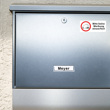 Brief silberner Briefkasten mit dem Namen "Meyer" und einem Aufkleber, der darum bittet, keine Werbung einzuwerfen.