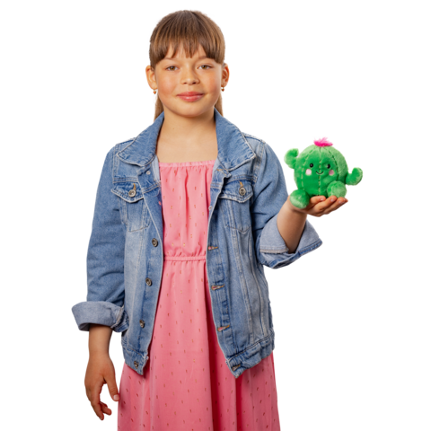 Ein Mädchen in einem rosa Kleid und einer Jeansjacke hält ein grünes Plüschspielzeug mit einer pinken Blume in der Hand."
(Note: The text is already in German and does not require translation.)