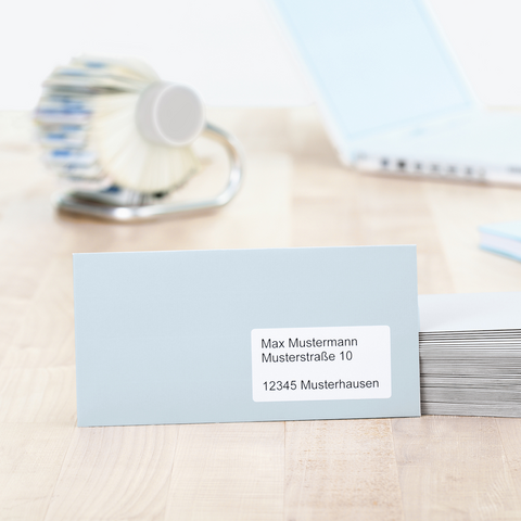 Blaue Kunststoffbox mit einer Etikette, die die Nummer 0134 zeigt, auf einem Tisch neben einem Notizblock und einem Stift.