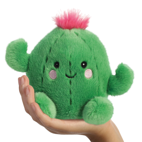 Ein grünes, kuscheliges Kaktus-Spielzeug mit einem lächelnden Gesicht und einer rosa Blüte, das in einer Hand gehalten wird.
