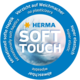 Rundes Logo von HERMA mit dem Text "SOFT TOUCH", das auf weiche Haptik, Elastizität und die Abwesenheit von Weichmachern hinweist.