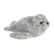 Plüschrobbe in grauer Farbe mit schwarzen Augen und einem runden Kopf, liegend auf einer flachen Oberfläche.