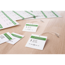 Mehrere Etiketten mit dem Wort "Fashion" und Größenangaben auf einem Holzuntergrund. Einige Etiketten sind mit Schnüren versehen.