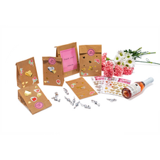 Geschenkverpackungen mit Aufklebern, eine Flasche Sekt und Blumenarrangement. Dekorative Elemente und Dankeskarten sind sichtbar.