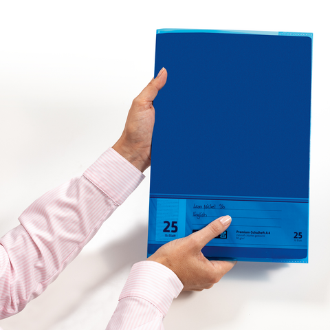 Eine Person hält einen blauen Ordner mit der Aufschrift "25" und einem Etikett für die Beschriftung in der Hand.