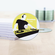 CD mit dem Titel 'Greatest Hits' und einem DJ-Design, umgeben von durchsichtigen CD-Hüllen auf einem Tisch.