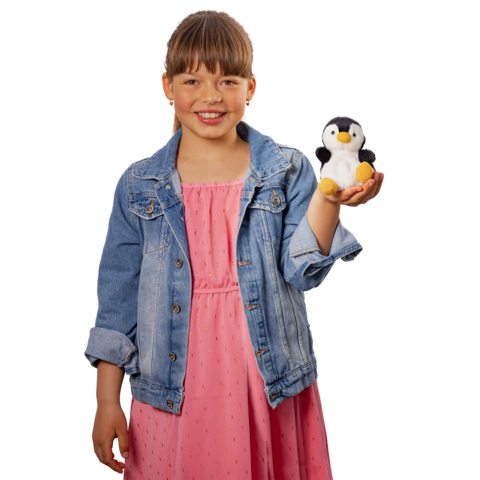 Ein Mädchen in einem rosa Kleid und einer Jeansjacke hält einen kleinen Plüsch-Pinguin in der Hand und lächelt."
(Note: The text is already in German and does not require translation. It is clear and fluent as it stands.)