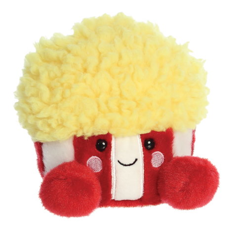 Plüschfigur eines Popcornbehälters mit gelbem, lockigem Oberteil und roten Seiten, lächelnd und freundlich gestaltet.