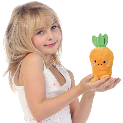 Ein Mädchen mit blonden Haaren hält ein orangefarbenes, karottenförmiges Plüschtier mit einem lächelnden Gesicht in den Händen.