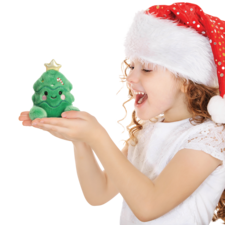 Ein Mädchen mit einem Weihnachtsmann-Hut hält ein grünes, lächelndes Plüschweihnachtsbaumspielzeug in den Händen.