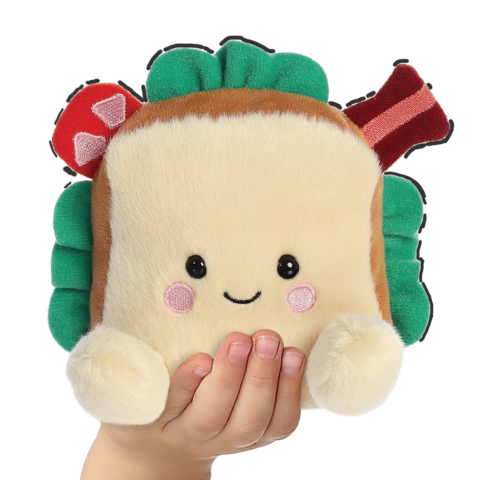 Ein gemütliches Sandwich-Plüschtier mit einem lächelnden Gesicht, bunten Zutaten und einer Hand, die es festhält.