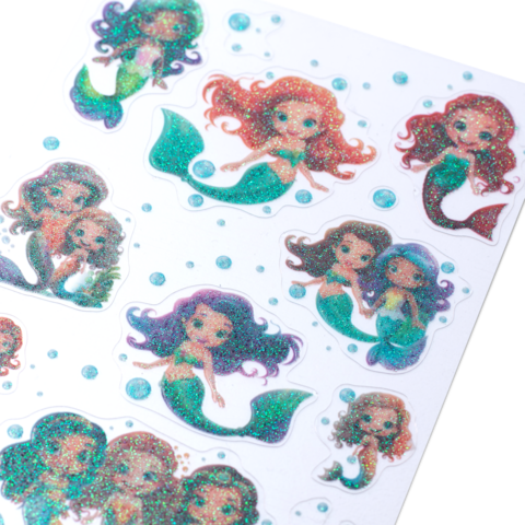 Glitzernde Meerjungfrauen-Sticker in verschiedenen Farben und Posen, umgeben von kleinen Blasen auf einem weißen Hintergrund.