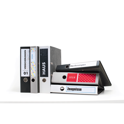 Fünf Ordner in verschiedenen Farben und Designs, beschriftet mit "Versicherungen", "Haus", "Rechnungen" und "Zeugnissen".