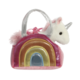 Ein buntes Handtäschchen mit einem Regenbogen-Motiv und einem Plüsch-Einhorn, das aus der Tasche schaut.