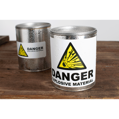 Metallbehälter mit Warnaufkleber für explosive Materialien, gekennzeichnet mit einem gelben Dreieck und dem Wort "DANGER".