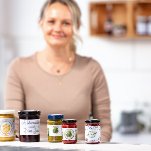 Fünf Gläser mit verschiedenen Lebensmitteln: Mehl, Reis, Müsli, Pasta und Haferflocken, jeweils mit beschrifteten Etiketten.