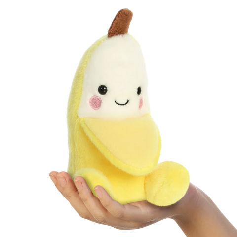 Eine Hand hält ein gelbes, weiches Bananen-Spielzeug mit einem lächelnden Gesicht und rosigen Wangen.