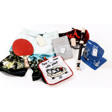 Bunte Shorts, ein Tischtennisschläger, ein Notizbuch, eine Flöte und verschiedene Spielzeuge auf einem weißen Hintergrund.