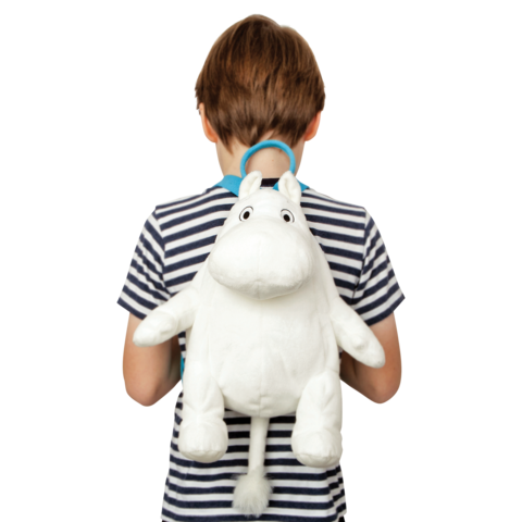 Ein Junge mit gestreiftem T-Shirt trägt einen weißen, plüschigen Mumin-Rucksack auf dem Rücken.
