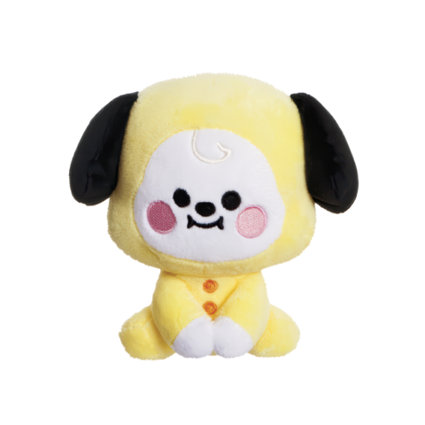 Ein gelbes Plüschspielzeug in Form eines Hundes mit schwarzen Ohren und einem lächelnden Gesicht, sitzt mit angezogenen Beinen.
