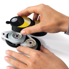 Eine Hand hält einen gelben und schwarzen Abroller, während die andere Hand die Schnur herauszieht.