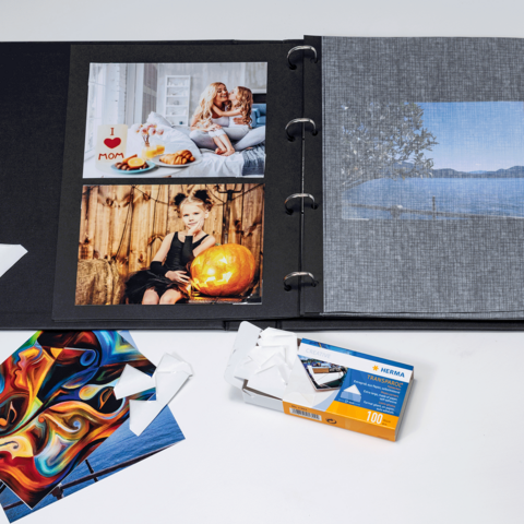 Ein Fotoalbum mit verschiedenen Bildern, darunter Porträts und Landschaften, sowie einige einzelne Fotokarten und eine Filmverpackung.