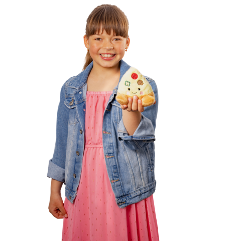 Ein Mädchen in einem rosa Kleid hält ein hübsch verziertes Brötchen in der Hand und lächelt freundlich.